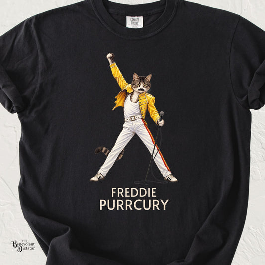 Black Comfort Colors t-shirt featuring a cat dressed as an iconic rock frontman in a yellow military-style jacket, microphone in hand and fist raised, with “Freddie Purrcury” below