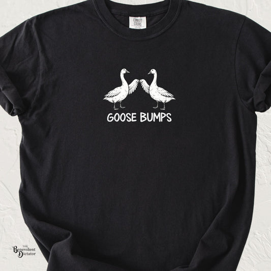 Black Comfort Colors t-shirt featuring two illustrated geese touching wings in a fist-bump pose above the words “Goose Bumps.”