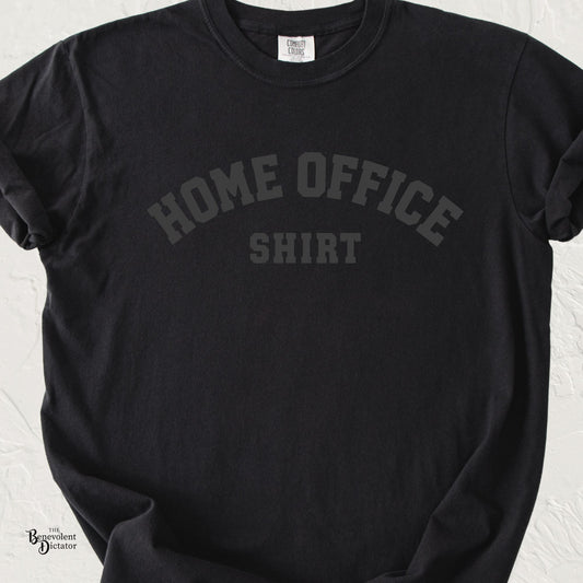 Black Comfort Colors t-shirt with subtle tonal text reading “Home Office Shirt” in a minimalist collegiate-style design.