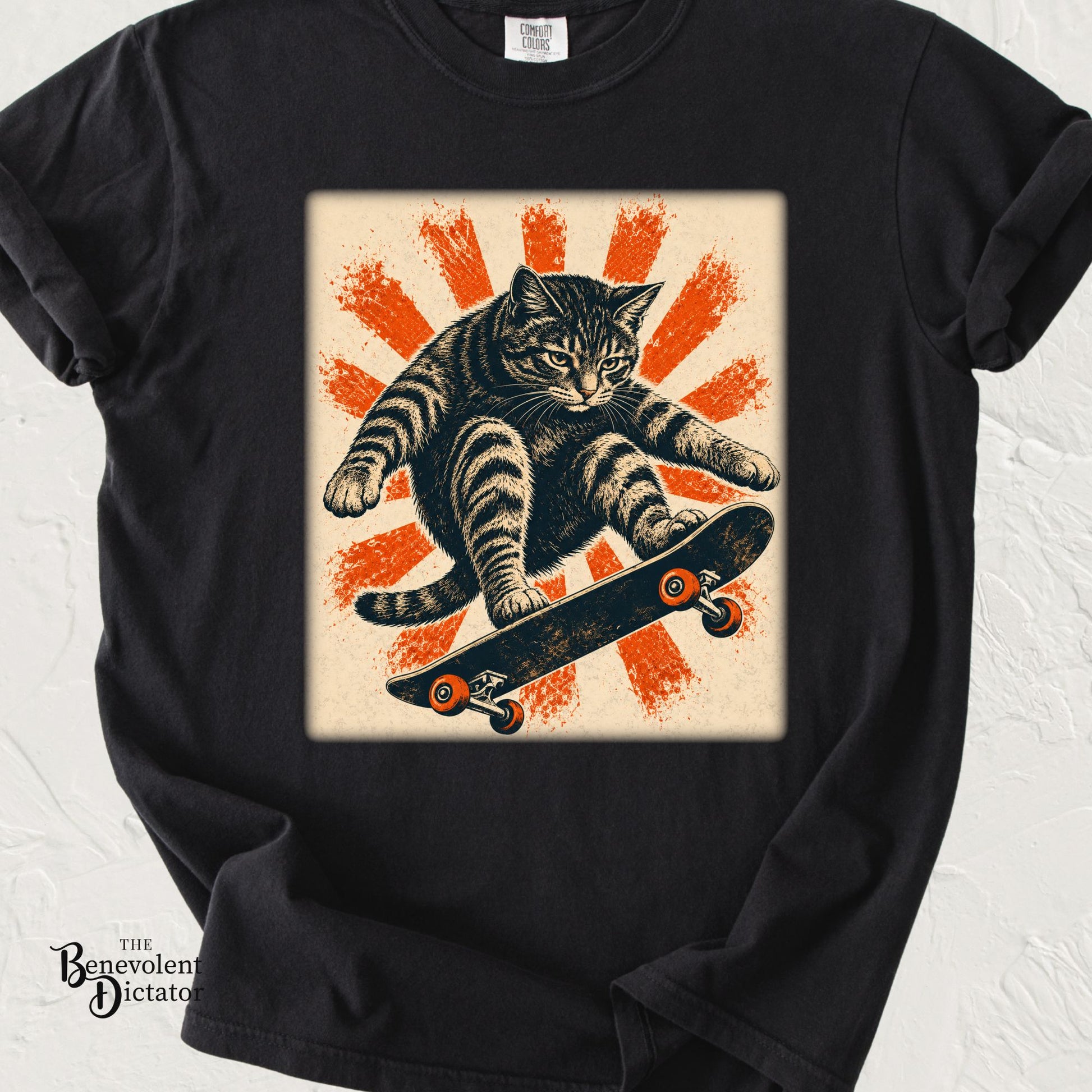 Vintage-style graphic t-shirt featuring a cat riding a skateboard mid-jump against a bold orange sunburst background.