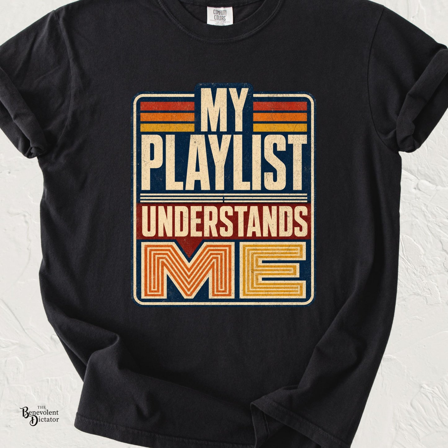 Black Comfort Colors t-shirt featuring retro distressed typography in cream, orange, red, and navy reading “My Playlist Understands Me.”