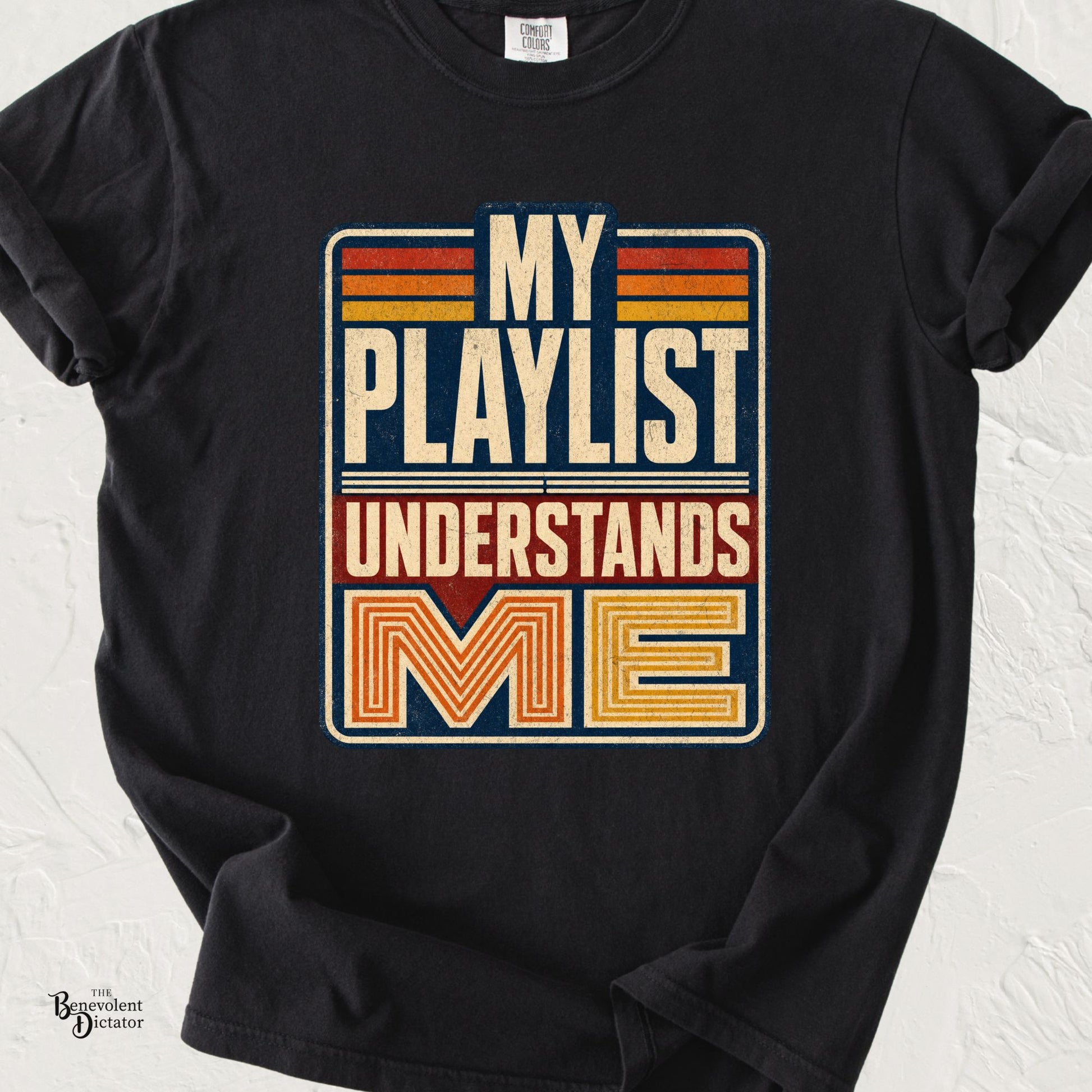 Black Comfort Colors t-shirt featuring retro distressed typography in cream, orange, red, and navy reading “My Playlist Understands Me.”