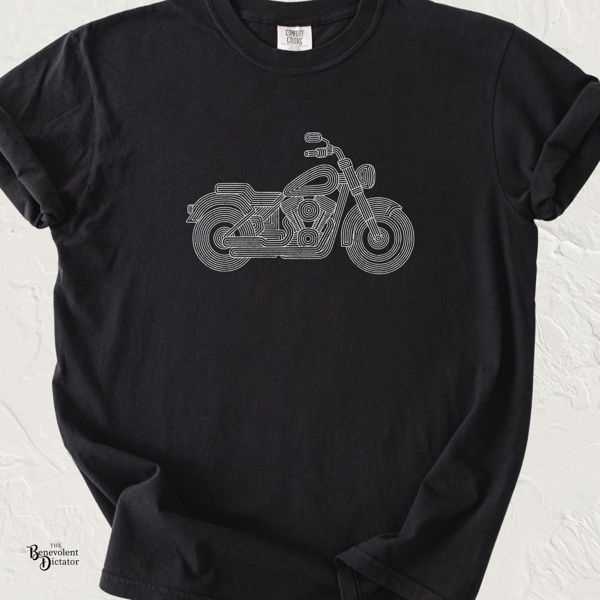 Black Comfort Colors t-shirt featuring a minimalist parallel-line illustration of a classic cruiser motorcycle in clean white line art.