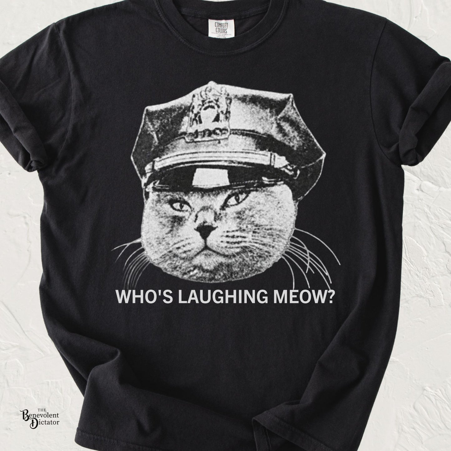 Vintage black-and-white grumpy cat wearing a police officer hat with the phrase "Who's Laughing Meow?" on a Comfort Colors® t-shirt.