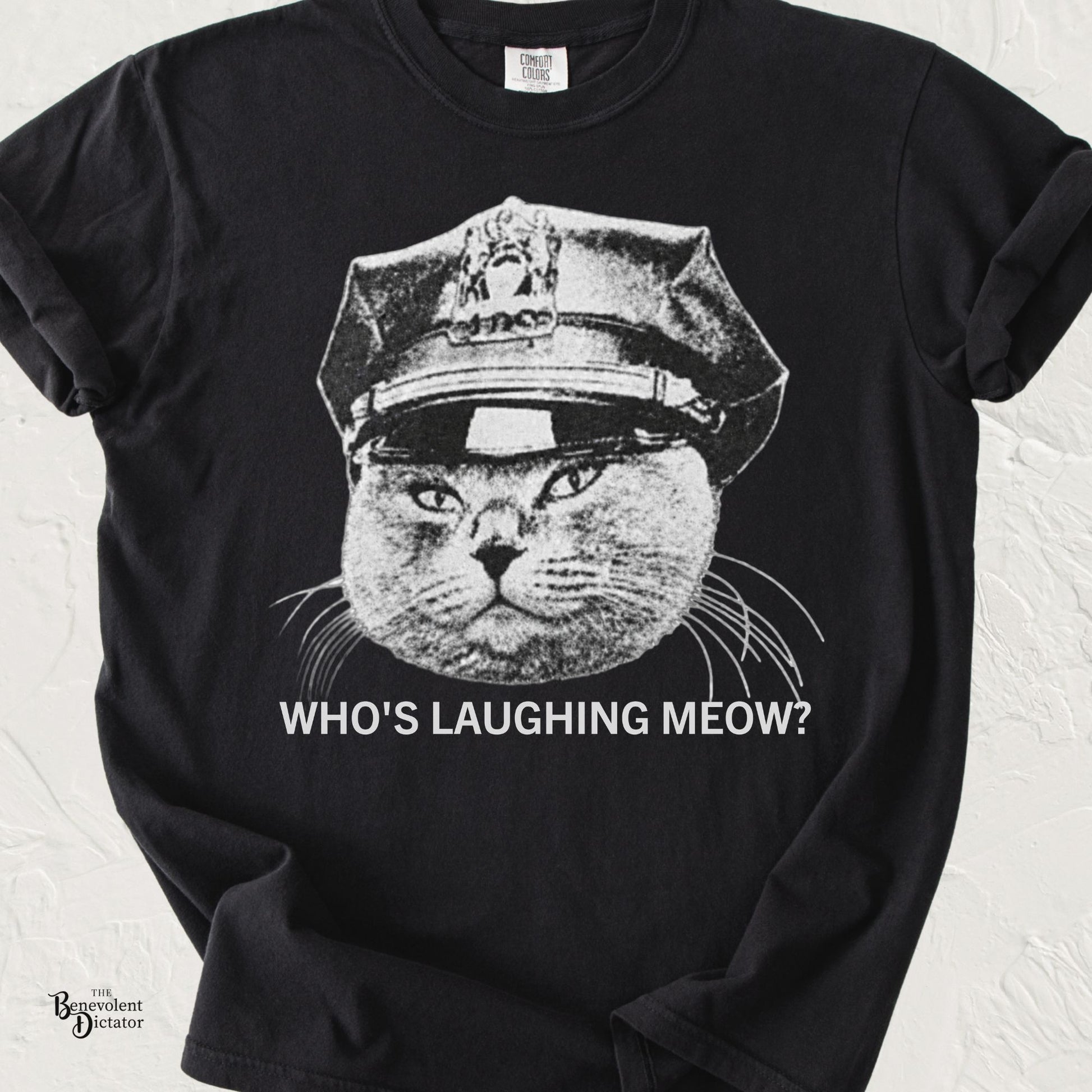 Vintage black-and-white grumpy cat wearing a police officer hat with the phrase "Who's Laughing Meow?" on a Comfort Colors® t-shirt.