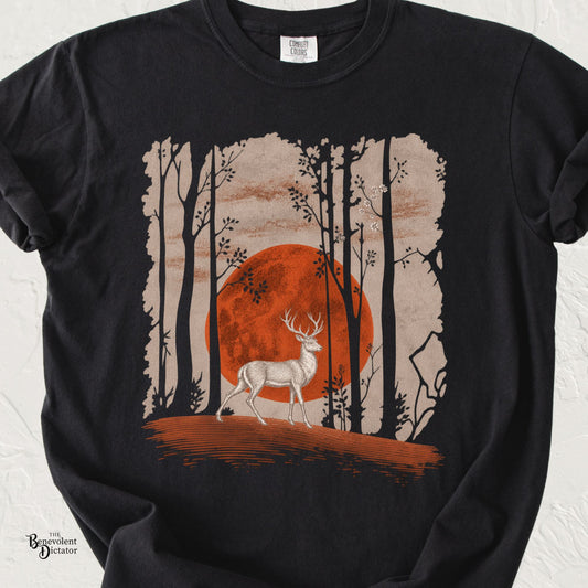 Vintage Japanese-inspired deer graphic t-shirt featuring a stag walking through a minimalist forest beneath a large rust-red sun.