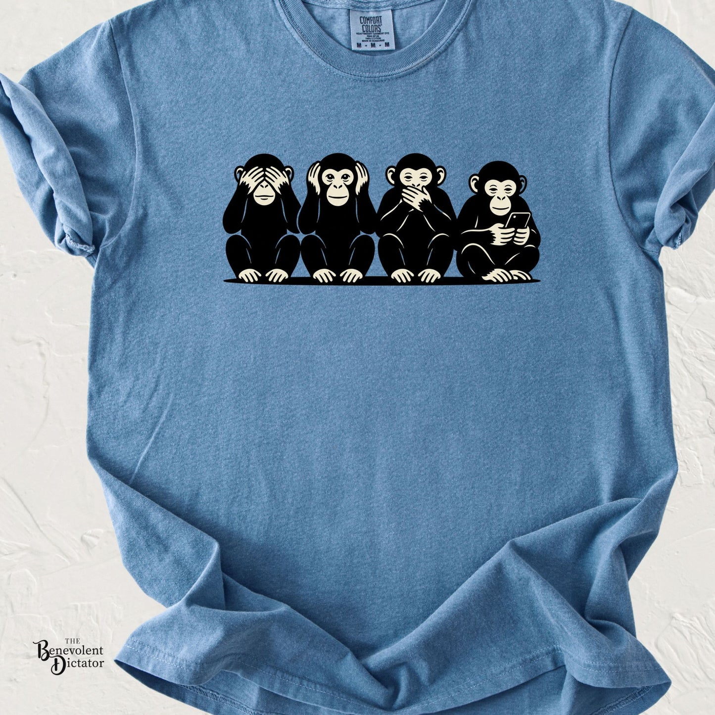 graphic t-shirt featuring four monkeys in the “see no evil, hear no evil, speak no evil” pose, with a fourth monkey looking at a smartphone.
