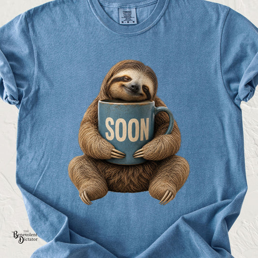 Funny sloth hugging an oversized coffee mug that says Soon on a vintage blue graphic tee