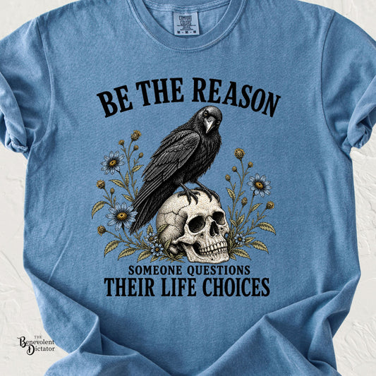 Vintage raven perched on a skull surrounded by wildflowers with Be the Reason Someone Questions Their Life Choices text