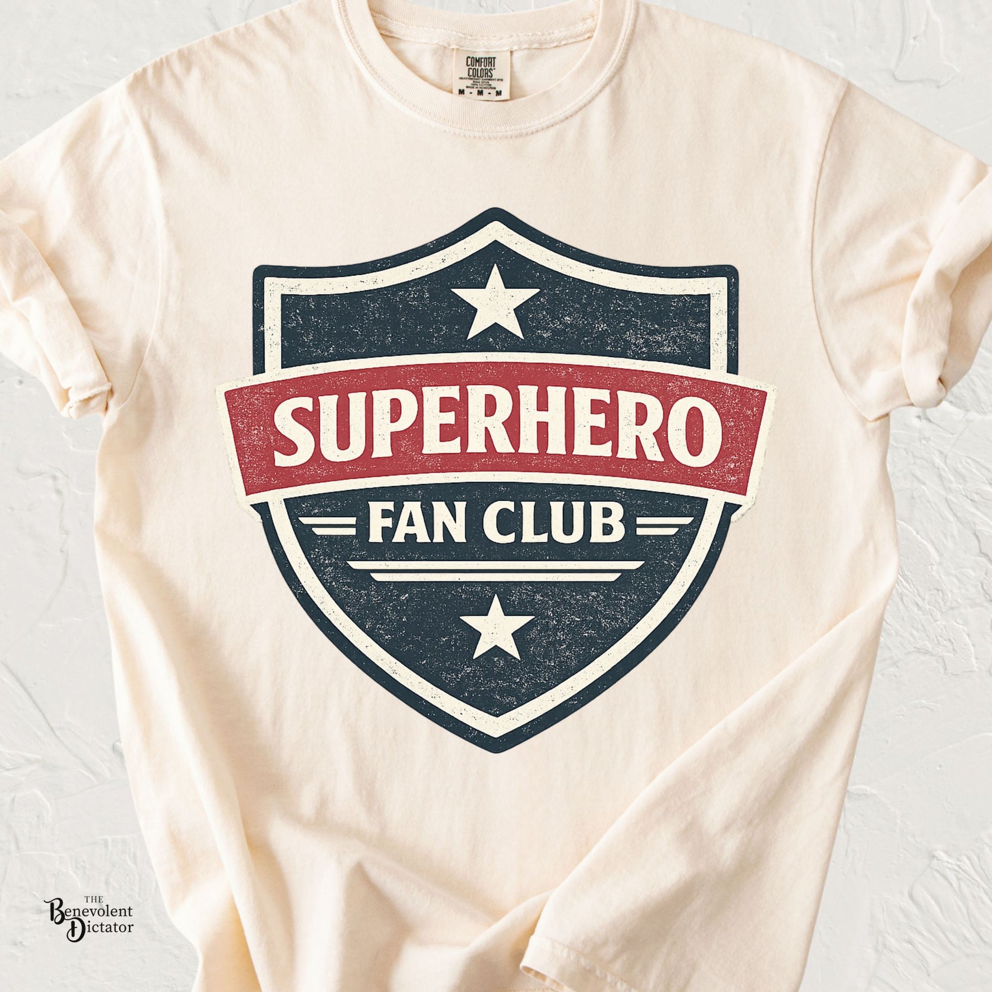 Vintage badge-style t-shirt featuring the phrase Superhero Fan Club in distressed comic-inspired lettering.