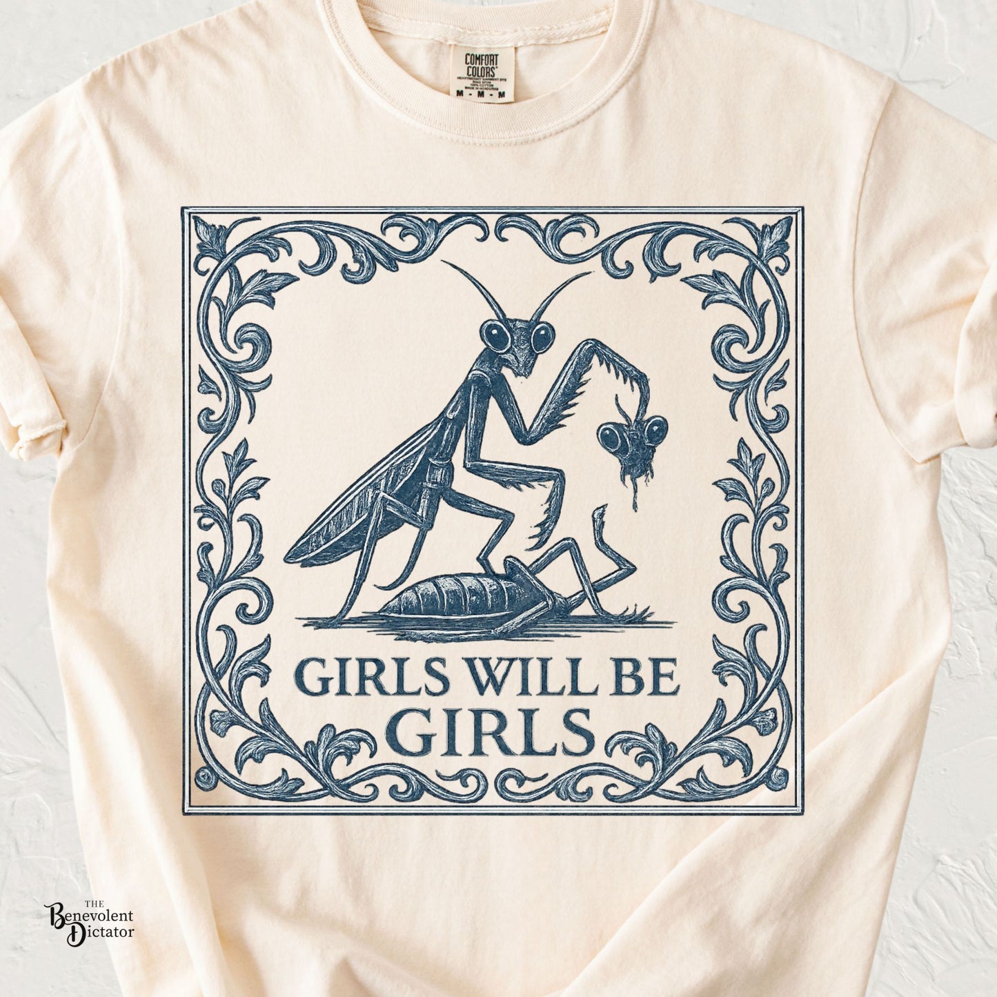 Vintage navy illustration of two praying mantises with ornate botanical framing and the phrase Girls Will Be Girls on an ivory Comfort Colors t-shirt.