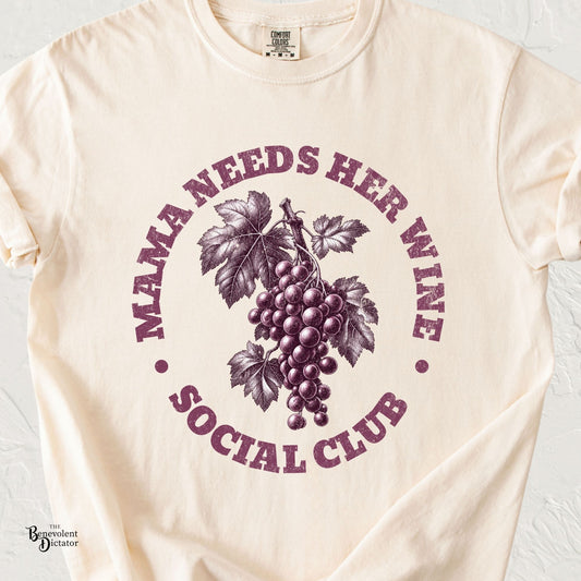 Ivory Colors t-shirt featuring vintage plum grape artwork with distressed text reading “Mama Needs Her Wine Social Club.”
