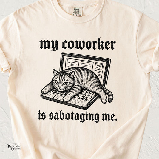 Funny cat lying across a laptop keyboard with My Coworker Is Sabotaging Me text in vintage blackletter typography