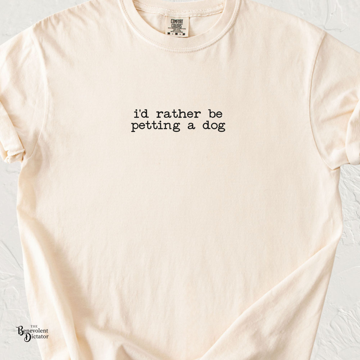 Ivory Comfort Colors t-shirt featuring minimalist black typewriter-style text reading “i'd rather be petting a dog” in a small, understated chest print.