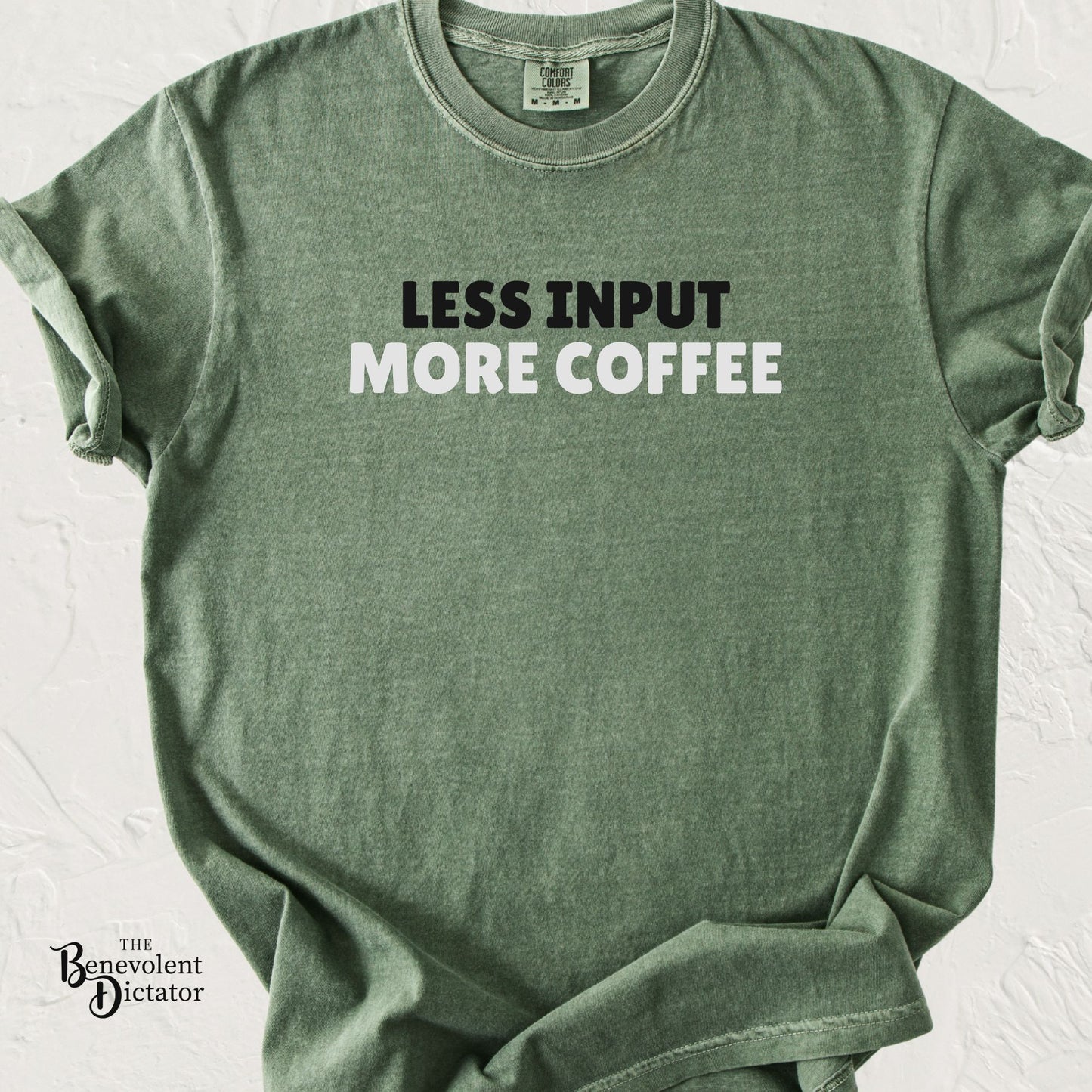 Moss green Comfort Colors t-shirt featuring bold minimalist typography reading “Less Input More Coffee” in black and white text.