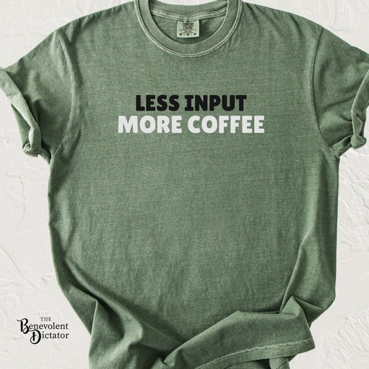 Moss green Comfort Colors t-shirt featuring bold minimalist typography reading “Less Input More Coffee” in black and white text.