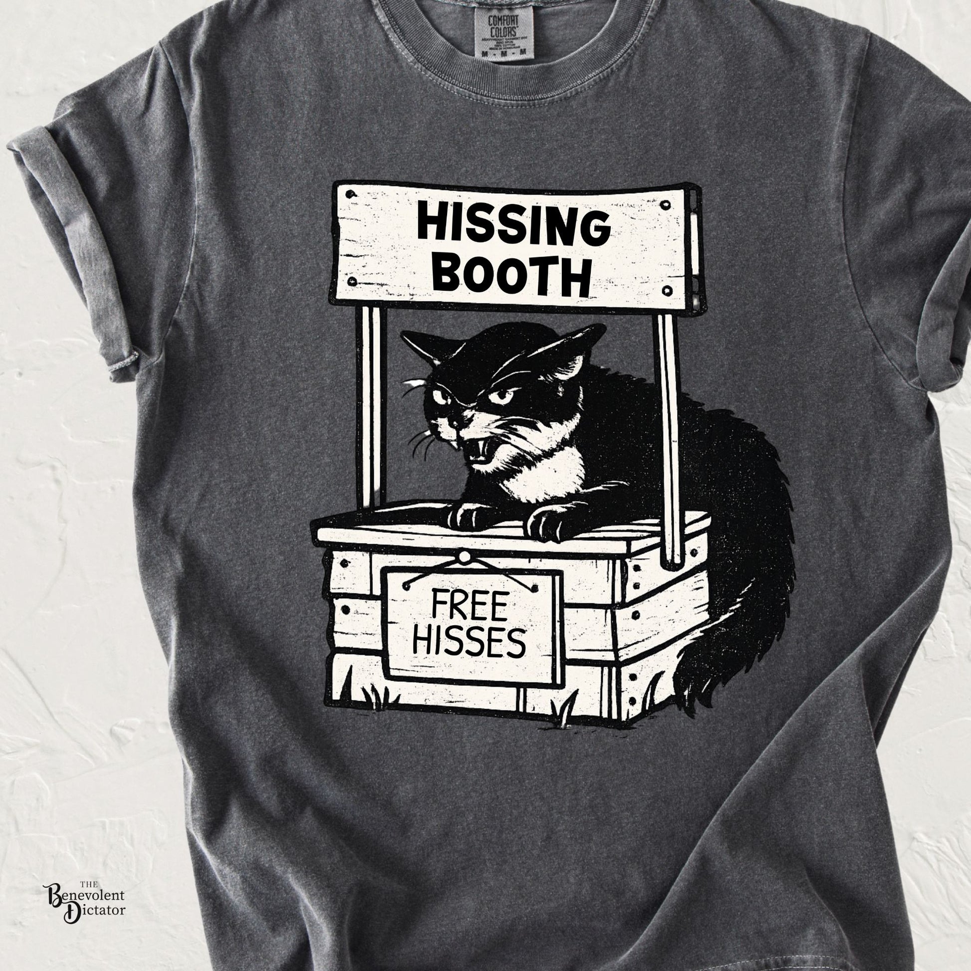 Funny cat t-shirt featuring an angry cat in a booth labeled Hissing Booth with a sign offering Free Hisses.