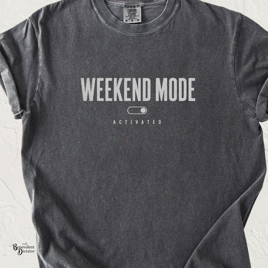 Pepper Comfort Colors t-shirt with minimalist distressed text reading “Weekend Mode Activated” and a simple toggle switch graphic.