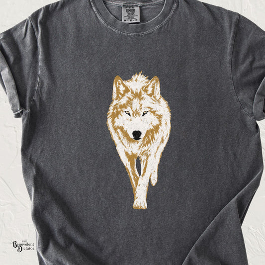 A dark gray washed t-shirt featuring a detailed graphic of a white and golden-brown wolf walking forward on the front. The t-shirt is laid flat against a light textured background, with a small 'The Basement Decorator' watermark in the bottom-left corner.