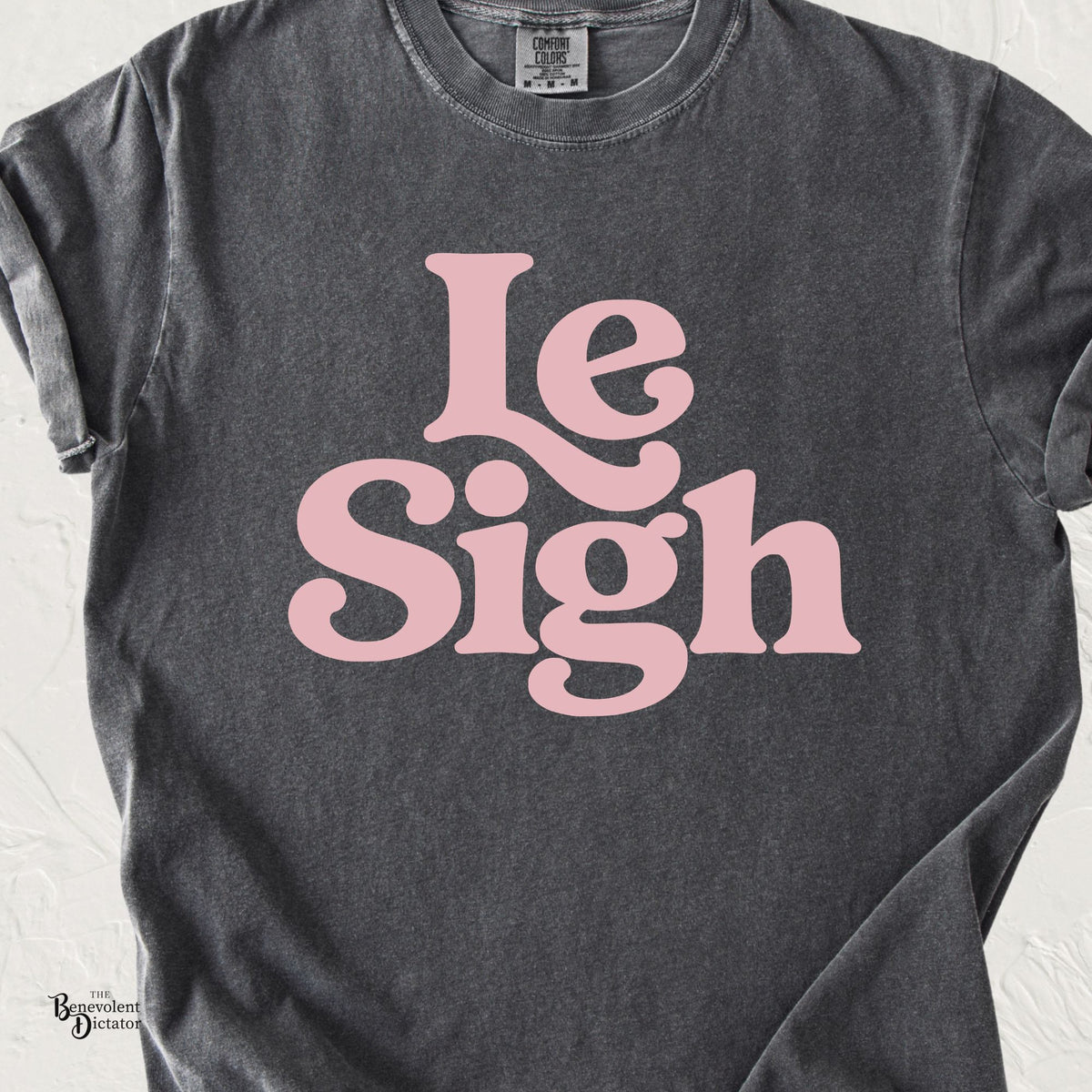 Pepper Comfort Colors t-shirt featuring oversized retro pink typography reading “Le Sigh.”