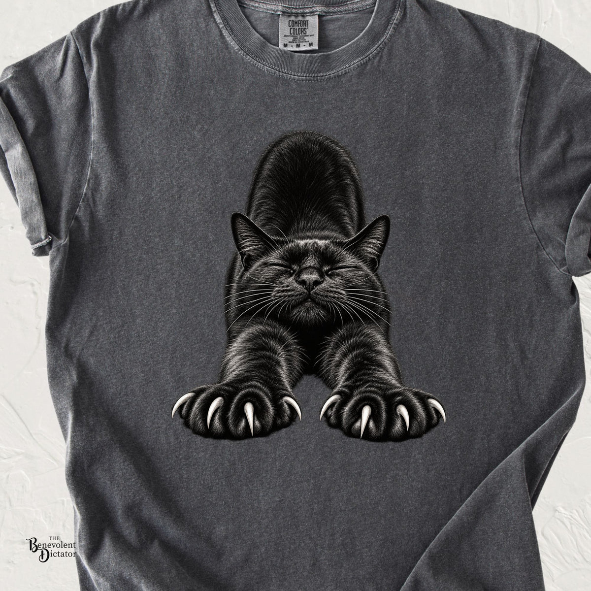 Pepper Comfort Colors t-shirt featuring a realistic black cat in a full forward stretch with closed eyes, extended paws and dramatically exposed claws.