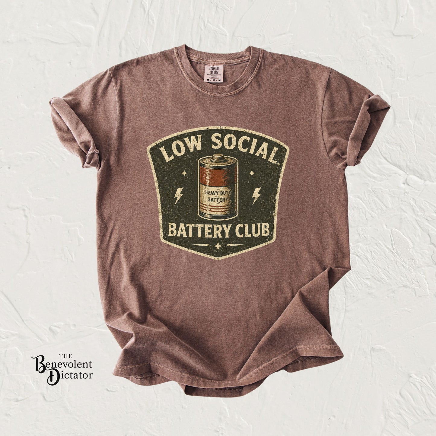 t-shirt with 'Low Social Battery Club' graphic on a textured white background