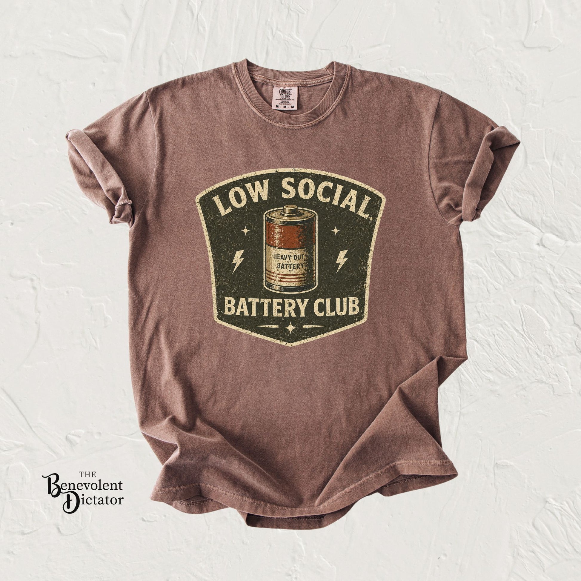 t-shirt with 'Low Social Battery Club' graphic on a textured white background
