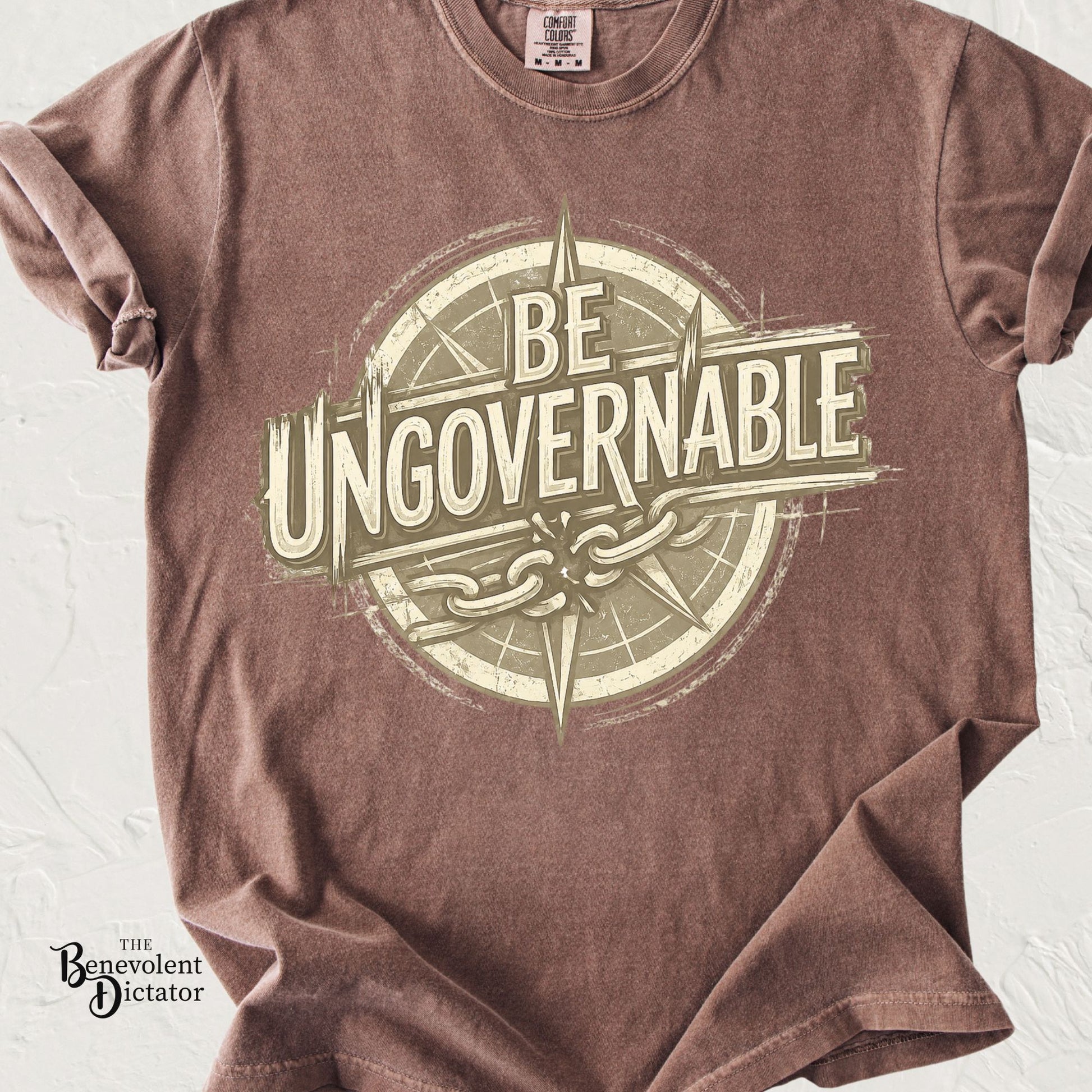 Vintage-style t-shirt featuring the phrase Be Ungovernable with compass and broken chain graphic.
