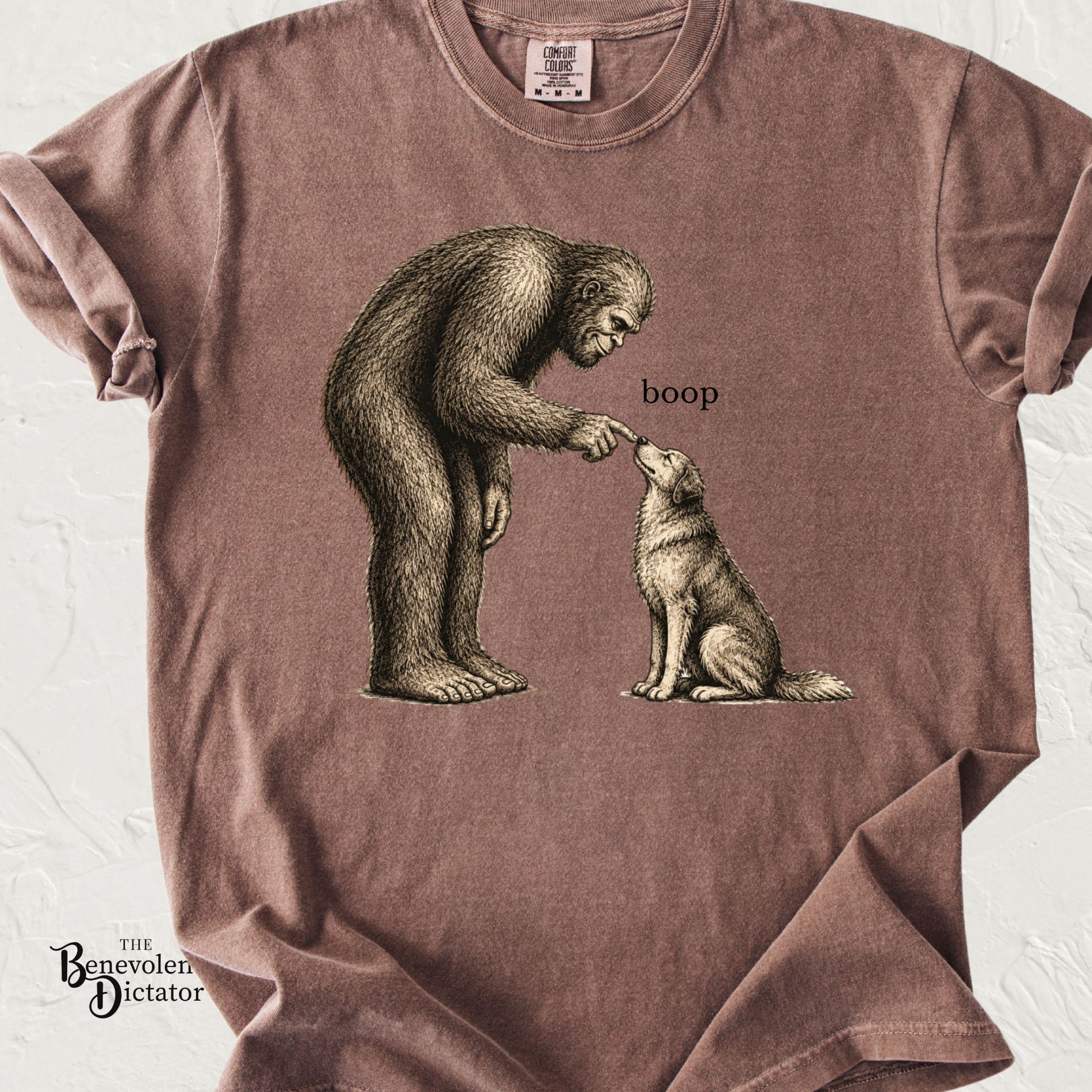 Funny Bigfoot t-shirt featuring Sasquatch gently booping a sitting dog.