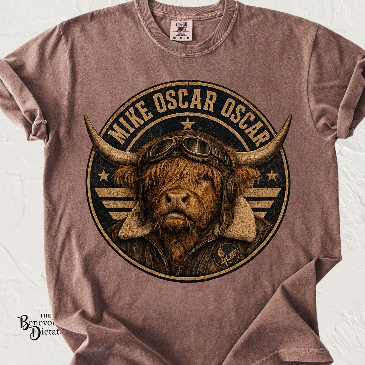 Comfort Colors espresso t-shirt featuring a vintage Highland cow wearing aviator goggles and a flight jacket with the phrase "Mike Oscar Oscar" around a distressed military-style emblem.