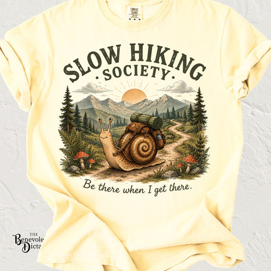 Vintage hiking snail wearing a backpack on a mountain trail with the phrase "Slow Hiking Society – Be there when I get there."